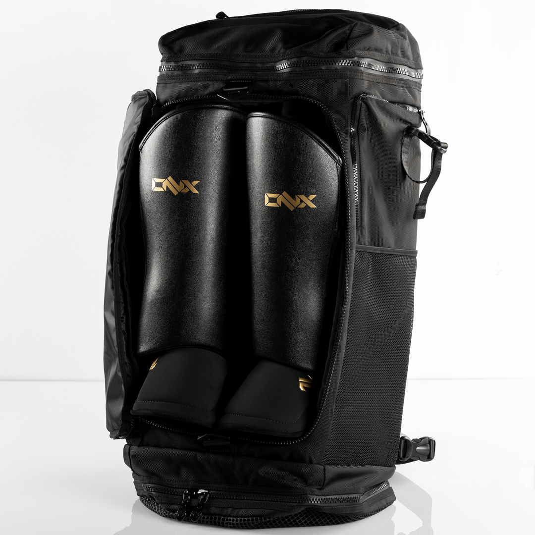 Black ONX backpack with gold branding on a white background and shin guard storage.
