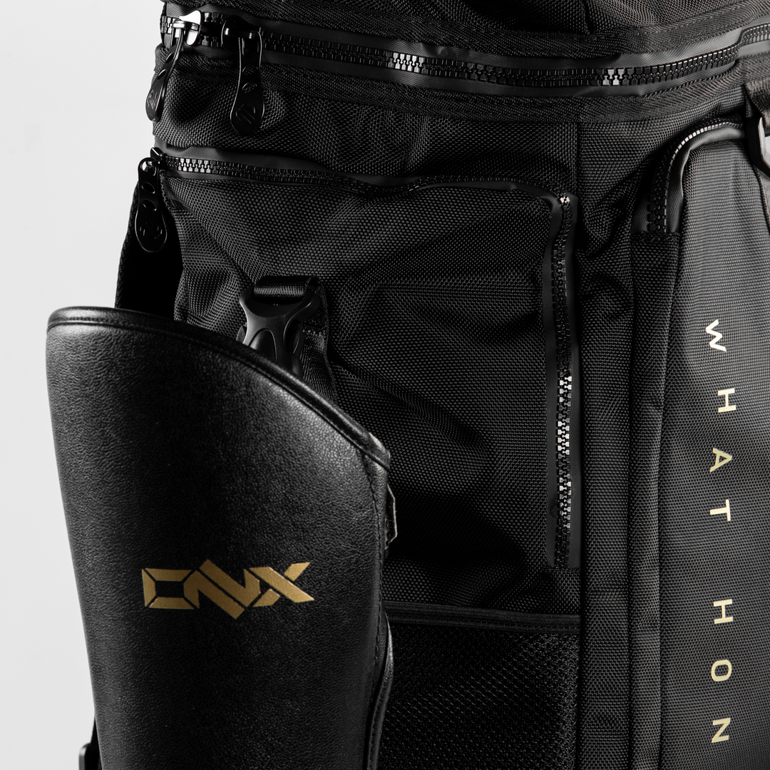 Black backpack with gold logo and text on a light gray background