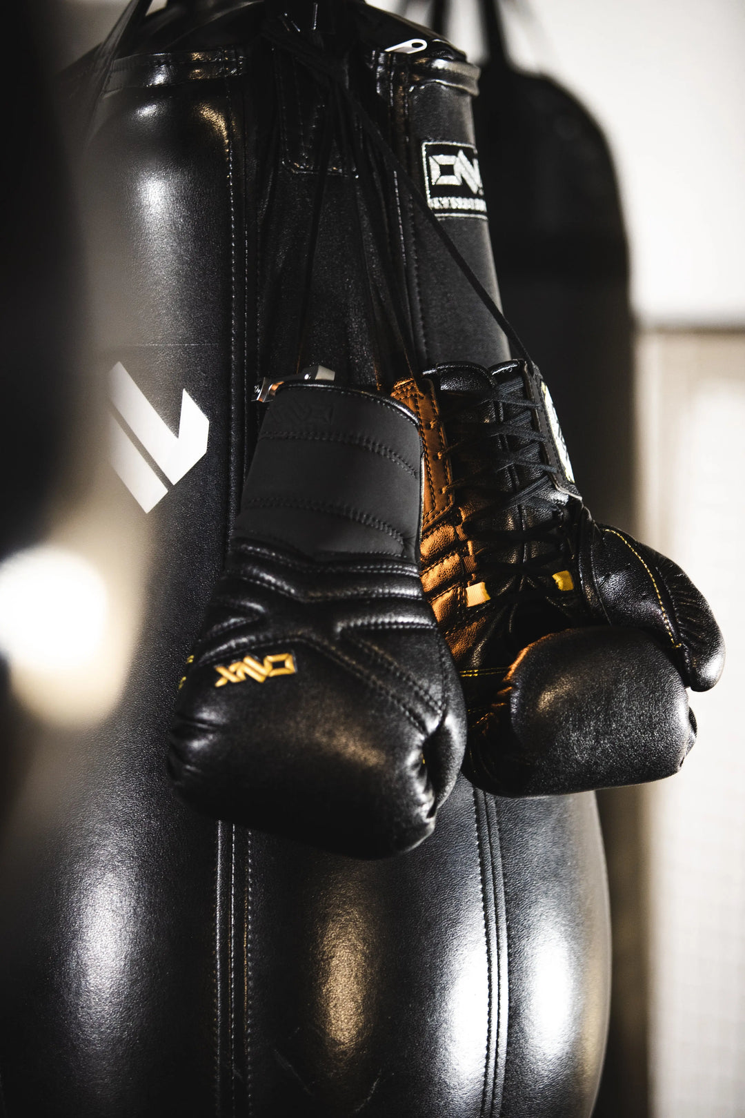 MMA Gloves—X-Factor Training Glove (Lace Up) by UFC and MMA Coach Trevor Wittman over a heavy bag.